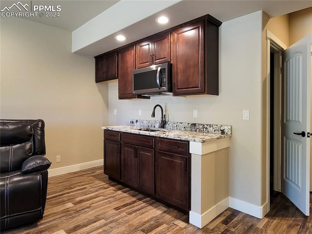 kitchen with dark brown cabinets, sink, and hardwood / wood-style floors