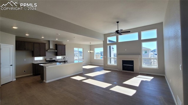 unfurnished living room featuring dark hardwood / wood-style floors, sink, and ceiling fan with notable chandelier