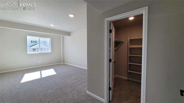 unfurnished bedroom featuring carpet flooring and a spacious closet