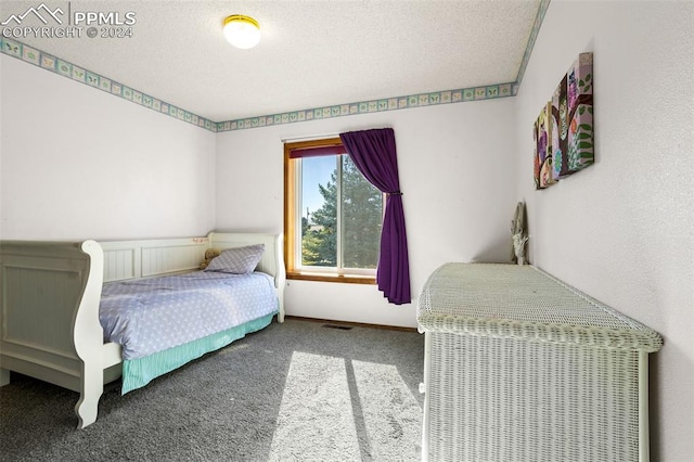 bedroom with carpet floors and a textured ceiling