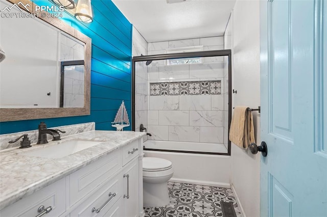 full bathroom featuring toilet, tile patterned floors, vanity, and shower / bath combination with glass door