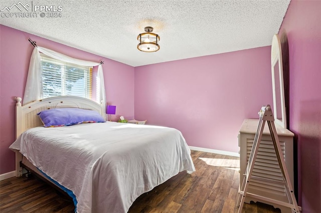 bedroom featuring dark hardwood / wood-style floors and a textured ceiling