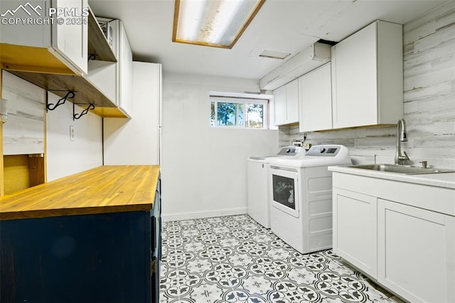 washroom featuring cabinets, separate washer and dryer, and sink