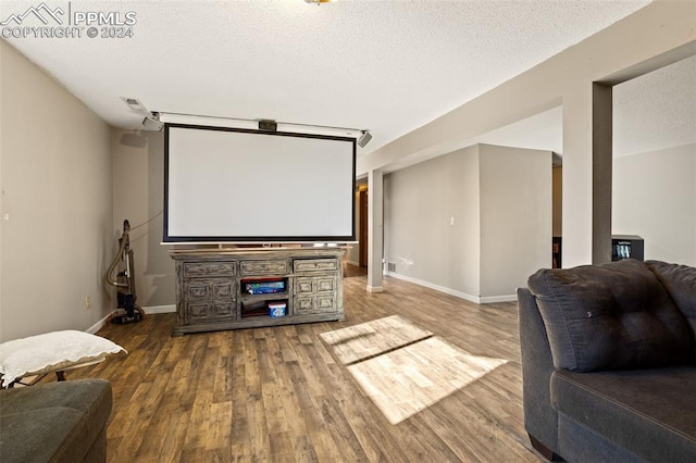 home theater featuring hardwood / wood-style flooring and a textured ceiling