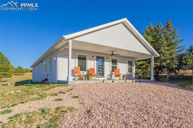 rear view of property featuring ceiling fan and a porch