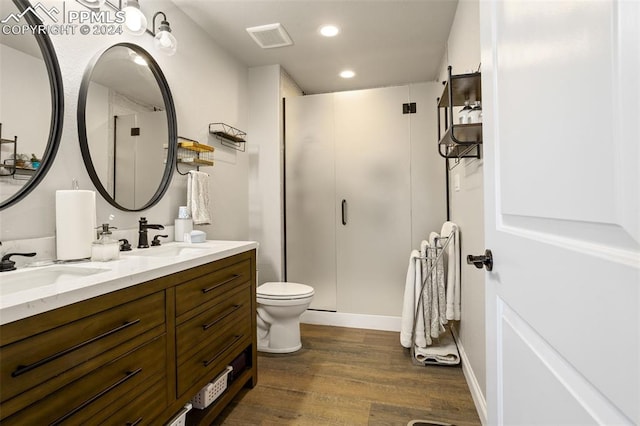 bathroom with wood-type flooring, toilet, an enclosed shower, and vanity