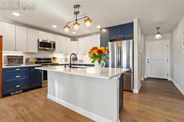 kitchen featuring hanging light fixtures, blue cabinetry, and appliances with stainless steel finishes