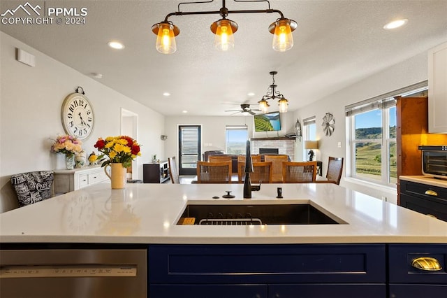 kitchen featuring dishwasher, a kitchen island with sink, sink, and ceiling fan