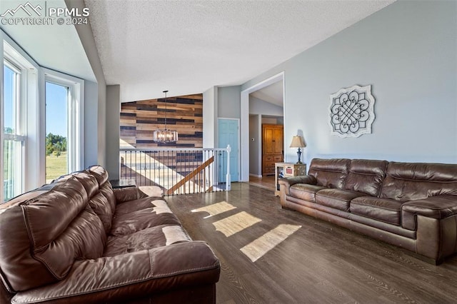 living room featuring a chandelier, vaulted ceiling, dark hardwood / wood-style floors, and a textured ceiling