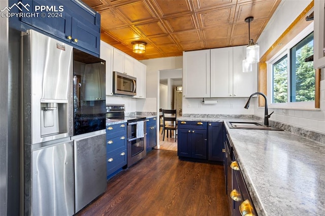 kitchen featuring blue cabinetry, sink, white cabinetry, pendant lighting, and stainless steel appliances