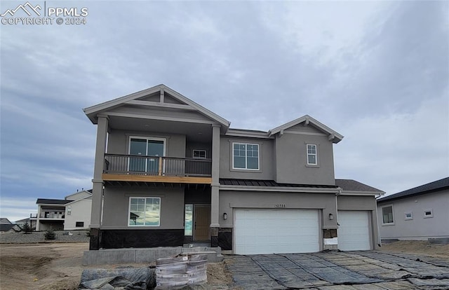 view of front of property featuring a balcony and a garage