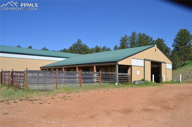 view of horse barn with an outbuilding