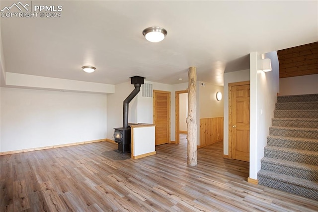 basement featuring hardwood / wood-style flooring and a wood stove