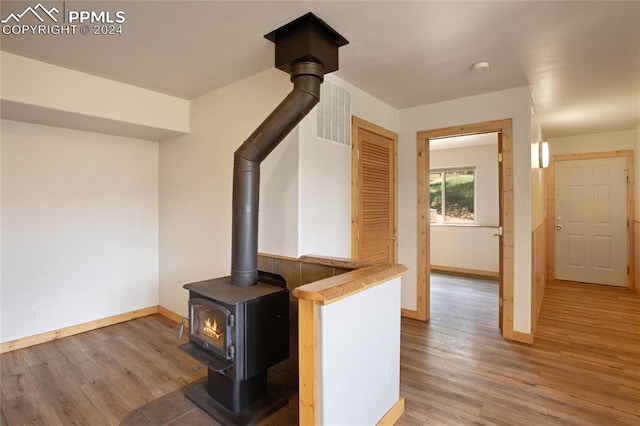 interior space with a wood stove and hardwood / wood-style flooring