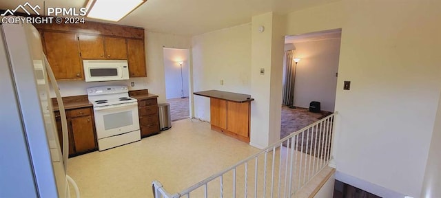 kitchen with white appliances and light carpet