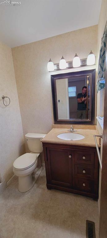 bathroom with tile patterned floors, vanity, and toilet