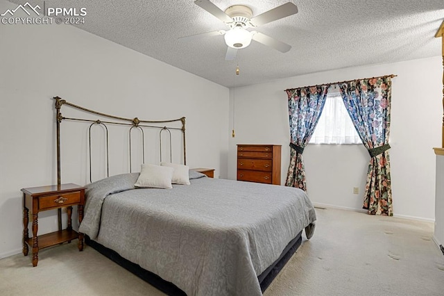 carpeted bedroom with ceiling fan and a textured ceiling