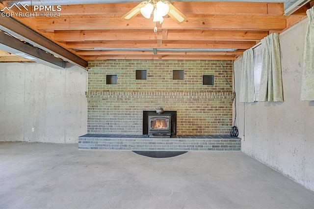 basement featuring ceiling fan and a wood stove