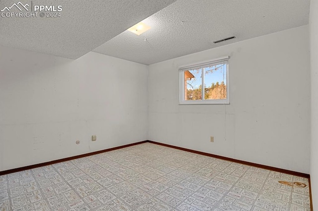 unfurnished room with a textured ceiling