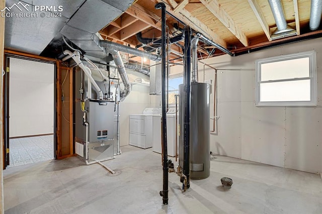 basement featuring heating unit, water heater, and washer and dryer