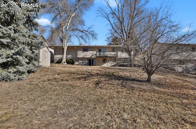 rear view of house with a storage shed and a wooden deck