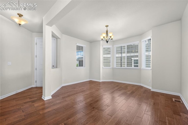 unfurnished room with dark hardwood / wood-style flooring and an inviting chandelier