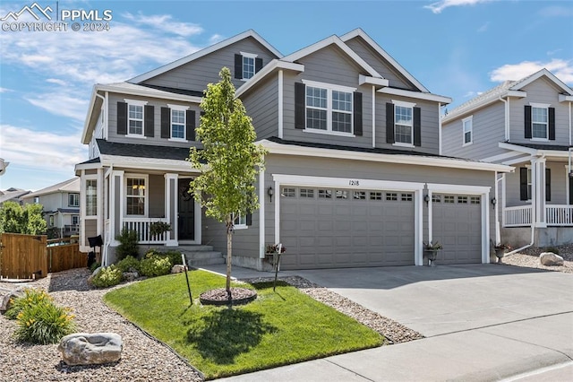 view of front facade with a front yard, a porch, and a garage