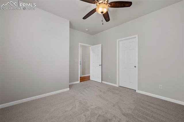 unfurnished bedroom with ceiling fan and light colored carpet