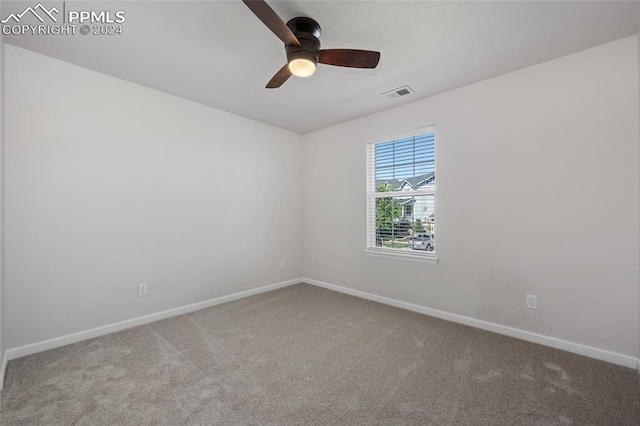 empty room featuring ceiling fan and carpet