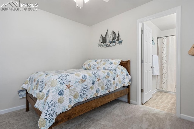 carpeted bedroom with ceiling fan and ensuite bath