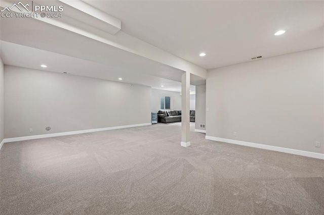 basement featuring light carpet