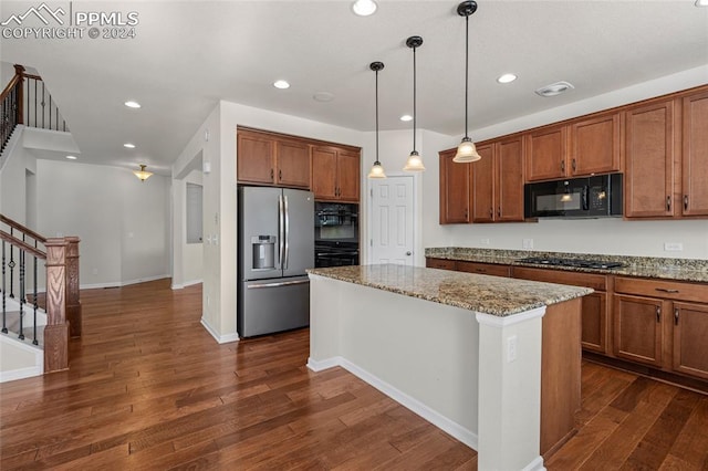 kitchen featuring decorative light fixtures, a kitchen island, stainless steel appliances, dark hardwood / wood-style flooring, and light stone counters