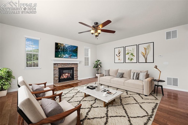 living room with ceiling fan, hardwood / wood-style floors, and a stone fireplace