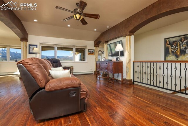 living room with hardwood / wood-style flooring, vaulted ceiling, ceiling fan, and baseboard heating