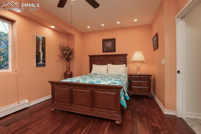 bedroom featuring dark hardwood / wood-style flooring, ceiling fan, and baseboard heating