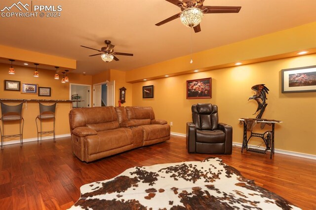 living room featuring dark wood-type flooring and ceiling fan