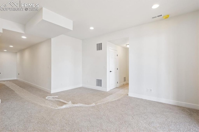 unfurnished room featuring light carpet