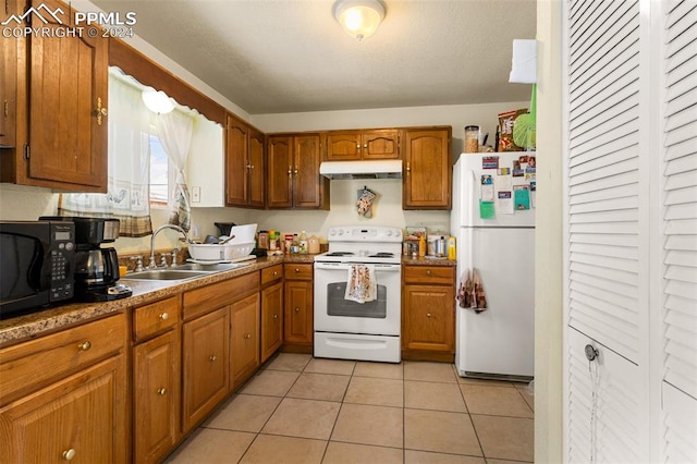 kitchen featuring white appliances, sink, and light tile patterned floors