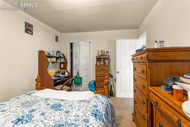 bedroom with light colored carpet and a textured ceiling