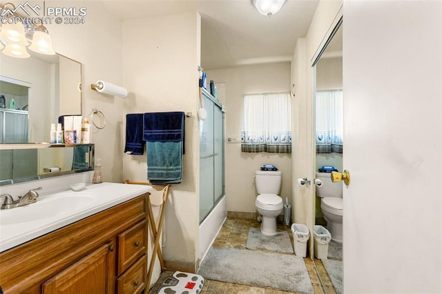 full bathroom with vanity, shower / bath combination with glass door, and toilet