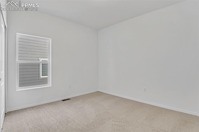 carpeted empty room featuring baseboards