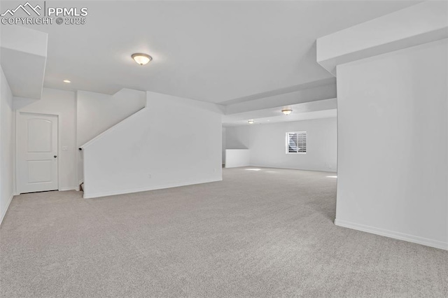 basement featuring carpet, baseboards, stairway, and recessed lighting