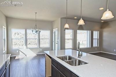 kitchen with a notable chandelier, sink, dark hardwood / wood-style flooring, and decorative light fixtures