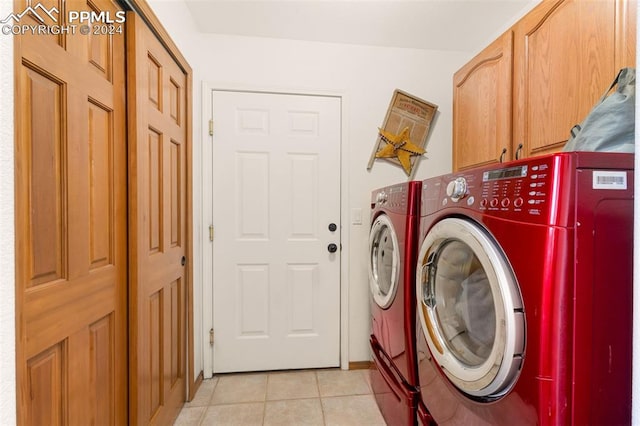 laundry room with separate washer and dryer, cabinets, and light tile patterned floors