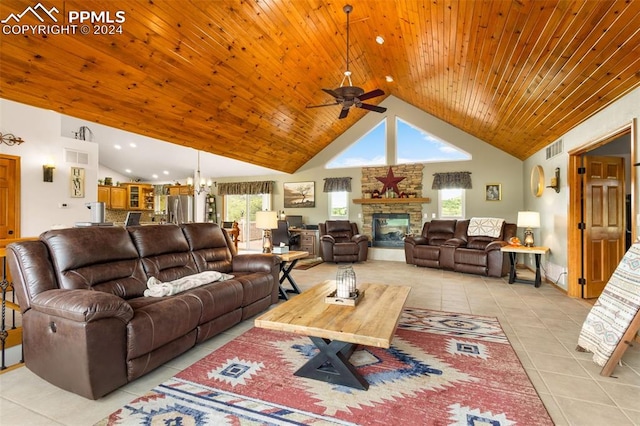 living room with ceiling fan with notable chandelier, plenty of natural light, light tile patterned floors, and high vaulted ceiling