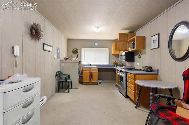 kitchen with appliances with stainless steel finishes, wooden walls, sink, and a baseboard radiator