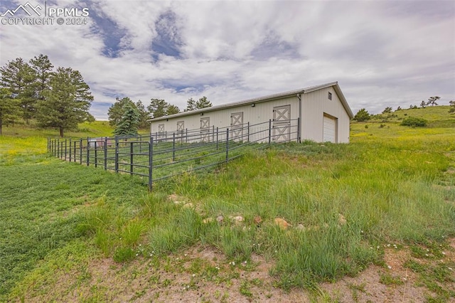 view of yard with an outdoor structure and a rural view