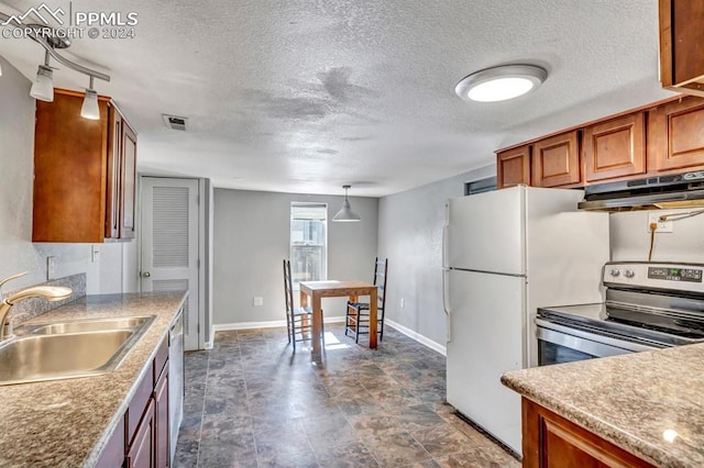 kitchen featuring sink, pendant lighting, appliances with stainless steel finishes, and a textured ceiling