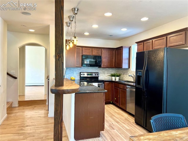 kitchen with light hardwood / wood-style floors, backsplash, decorative light fixtures, black appliances, and sink