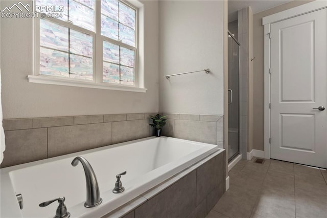 bathroom featuring plus walk in shower, tile patterned floors, and a healthy amount of sunlight